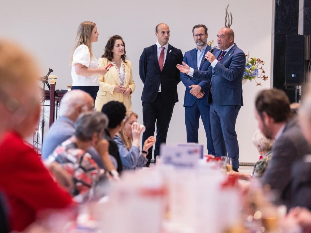Burgemeester en wethouders vertellen voor publiek.