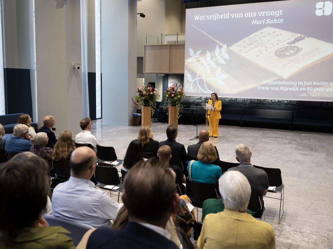 zaal met mensen waar burgemeester een toespraak geeft