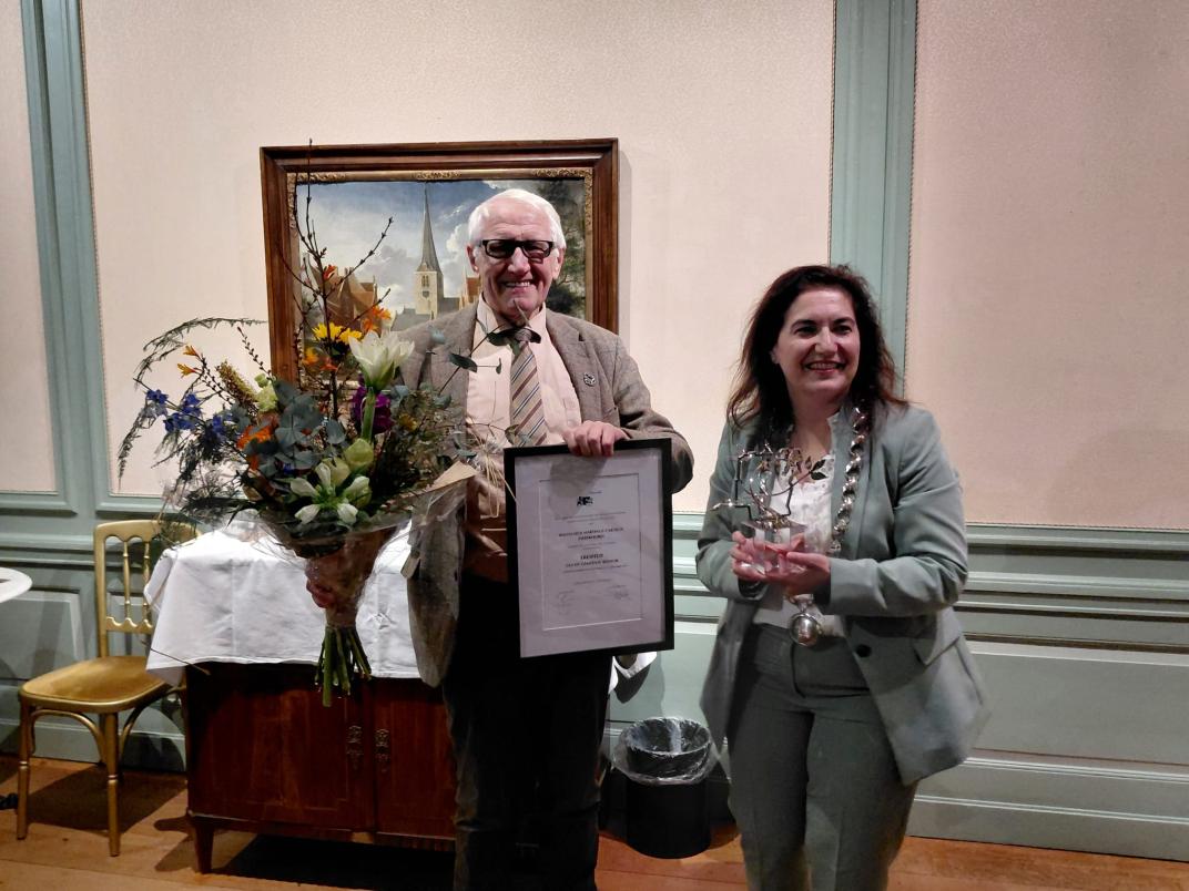 Wim Zweekhorst staat samen met Huri Sahin met een bos bloemen in zijn handen