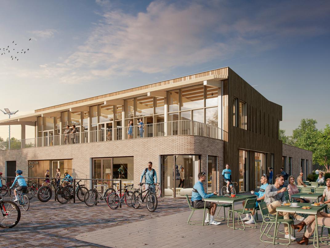 Het terras behorend bij MFA Sportpark Rijswijk. Op het terras zitten veel sporters en supporters. Verder staan er fietsen geparkeerd naast het restaurant en lopen er mensen rond. 