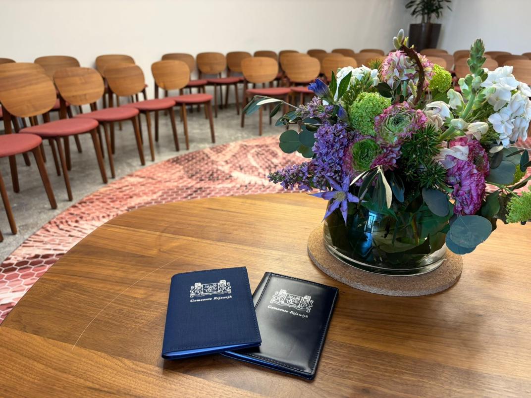 Trouwboekjes met trouwzaal en bloemen op de achtergrond