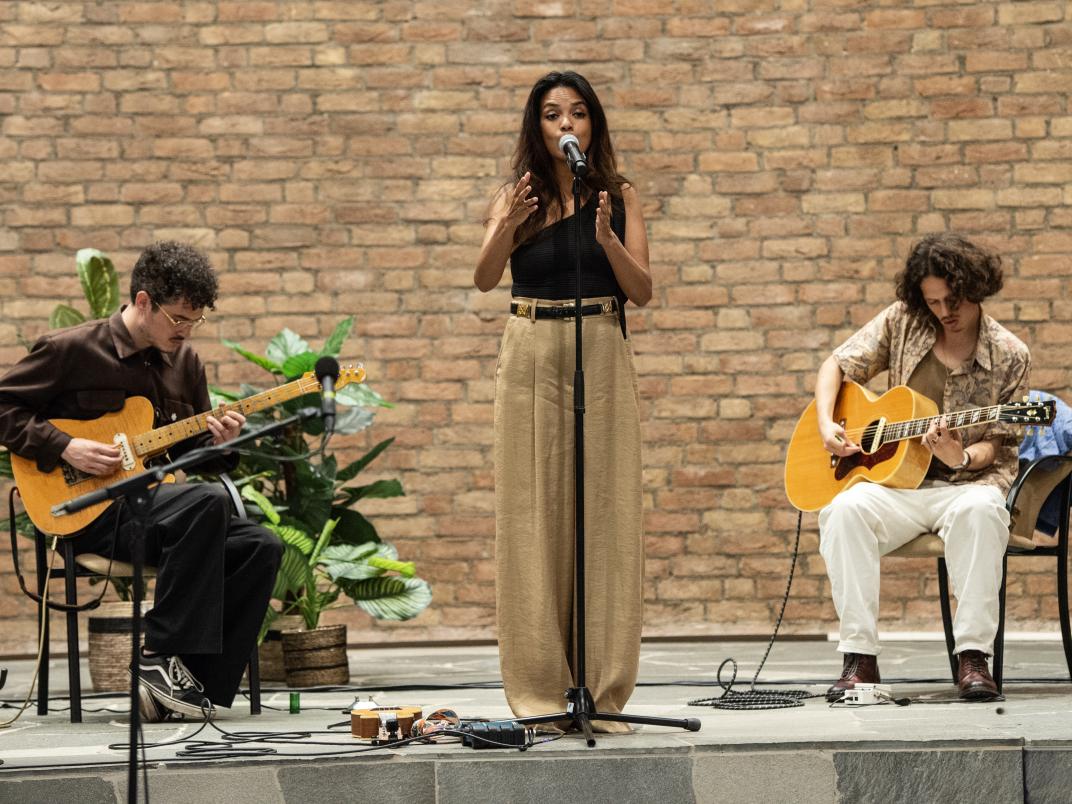 Een zangeres en twee gitaristen treden op. 