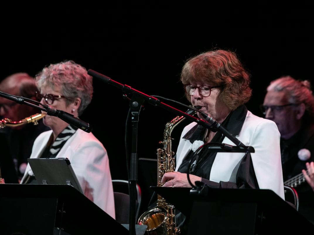 Twee vrouwen bespelen een saxofoon.