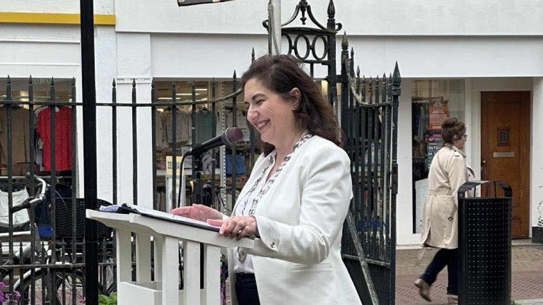 Burgemeester staand achter een spreektafel.